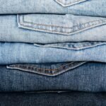 Closeup of stack of blue denim pants neatly arranged according to color from lightest to darkest